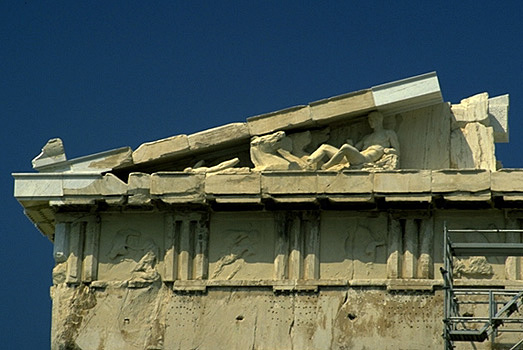 The Parthenon, detail of the eastern facade. - This photo shows the left (south) half of the entablature (epistyle, triglyph-metope frieze, horizontal and raking geison, pediment). The metopes, now worn and defaced, depict the Gigantomachy (or Battle of the Gods and Giants). Note also the numerous ho by Kevin T. Glowacki and Nancy L. Klein