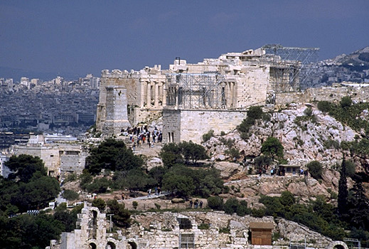 The western end of the Acropolis. - Visible the Beule Gate, the Propylaia, Nike Bastion and Temple of Athena Nike (under scaffolding), and the Agrippa Monument. View from the southwest (from near the Philopappos Monument). Photo taken in 1998. by Kevin T. Glowacki and Nancy L. Klein