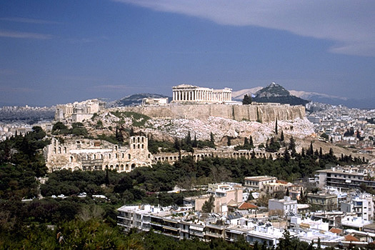 View of the Acropolis and the South Slope from the southwest (from near the Philopappos Monument). - In the background to the right of the Parthenon are Mt. Lykabettos and Mt. Penteli. Photo taken in 1998.