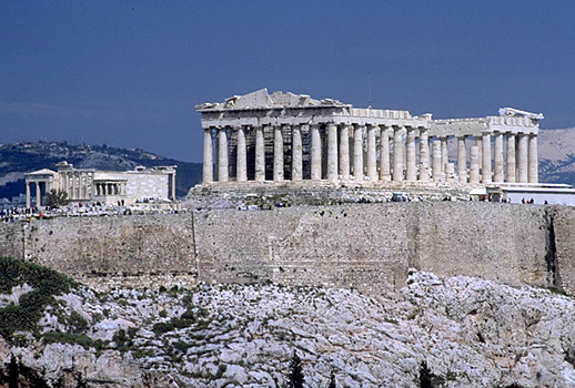 View of the Erechtheion, the Parthenon, and the south wall of the Acropolis. - View from the southwest (from near the Philopappos Monument). In the background to the right of the Parthenon are Mt. Lykabettos and Mt. Penteli. Photo taken in 1998.