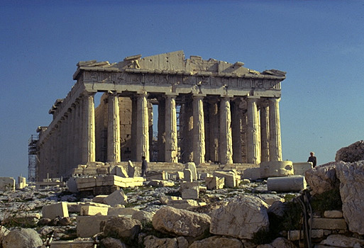 The Parthenon, western facade. - View from east of the Temple of Athena Nike. The large limestone boulders in the forground are part of the Mycenaean fortification wall.